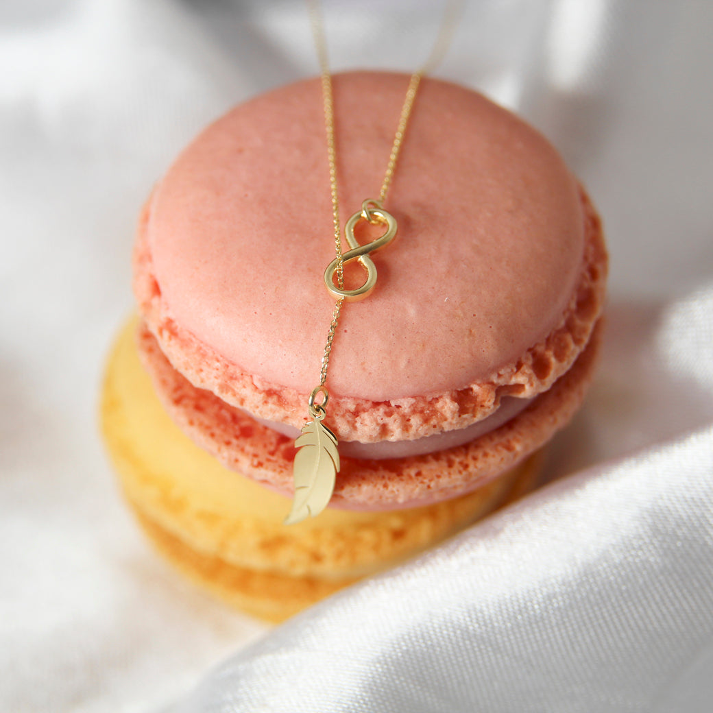 Złoty naszyjnik typu krawatka nieskończoność z piórkiem 333